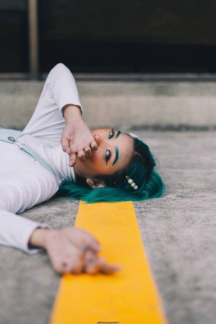 photo of woman laying on road