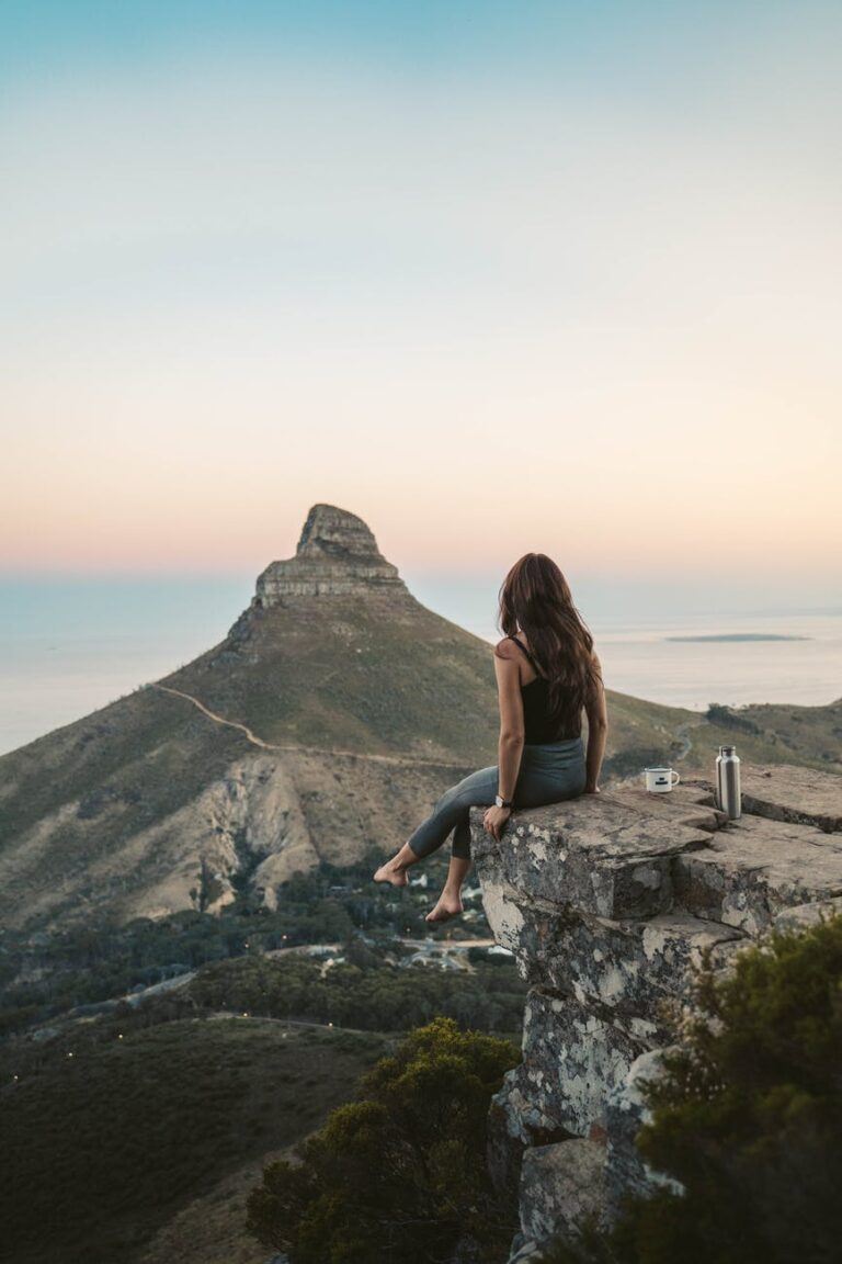 a woman on a rocky cliff with a scenic view