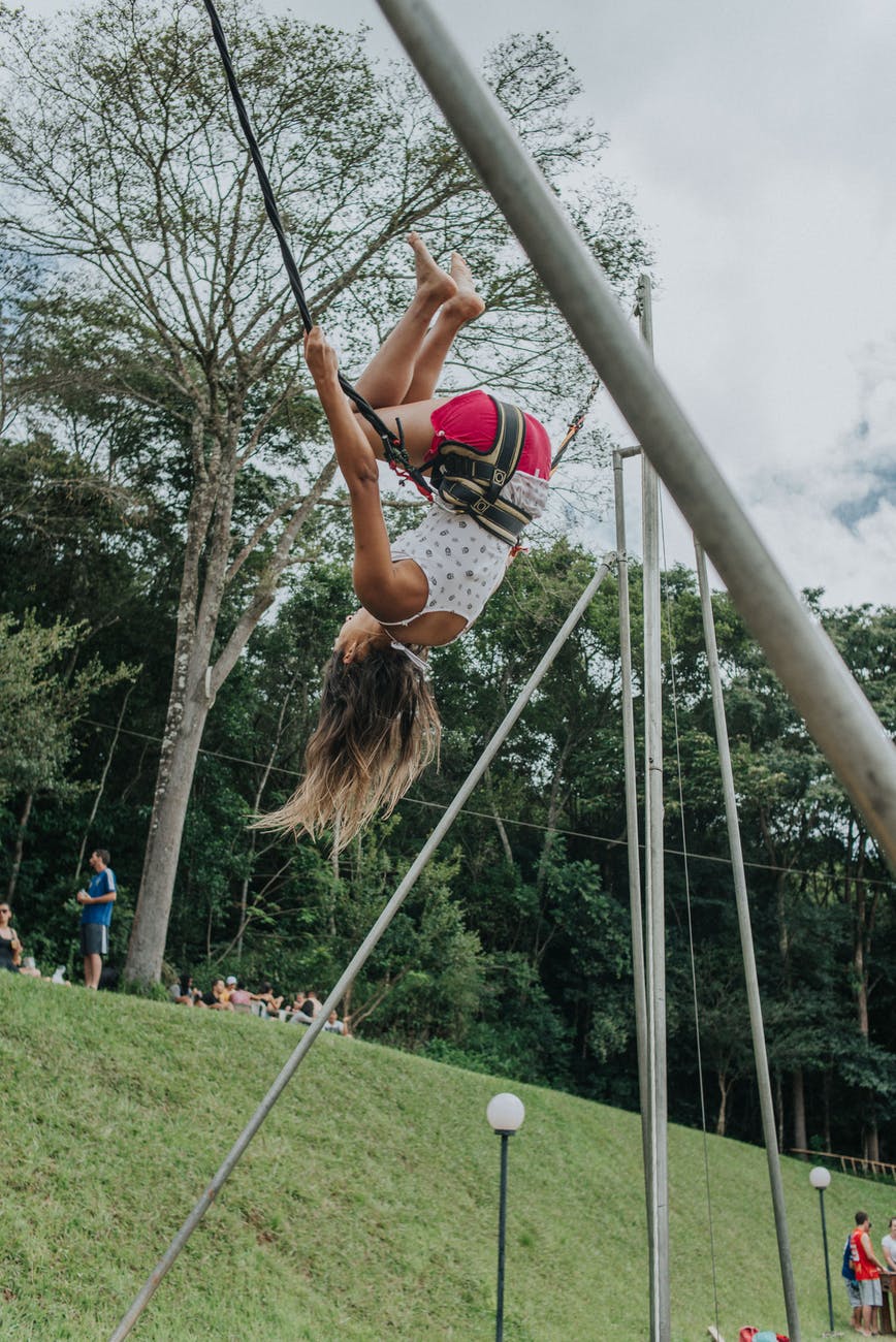 a woman doing a backflip while on a bungee trampoline