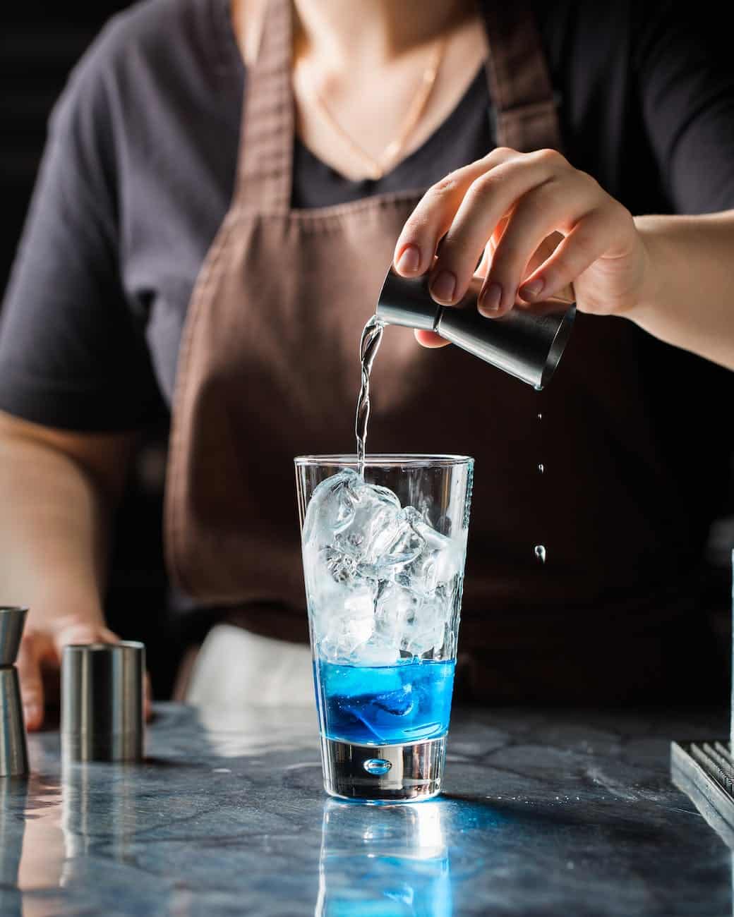 person mixing drinks on cup