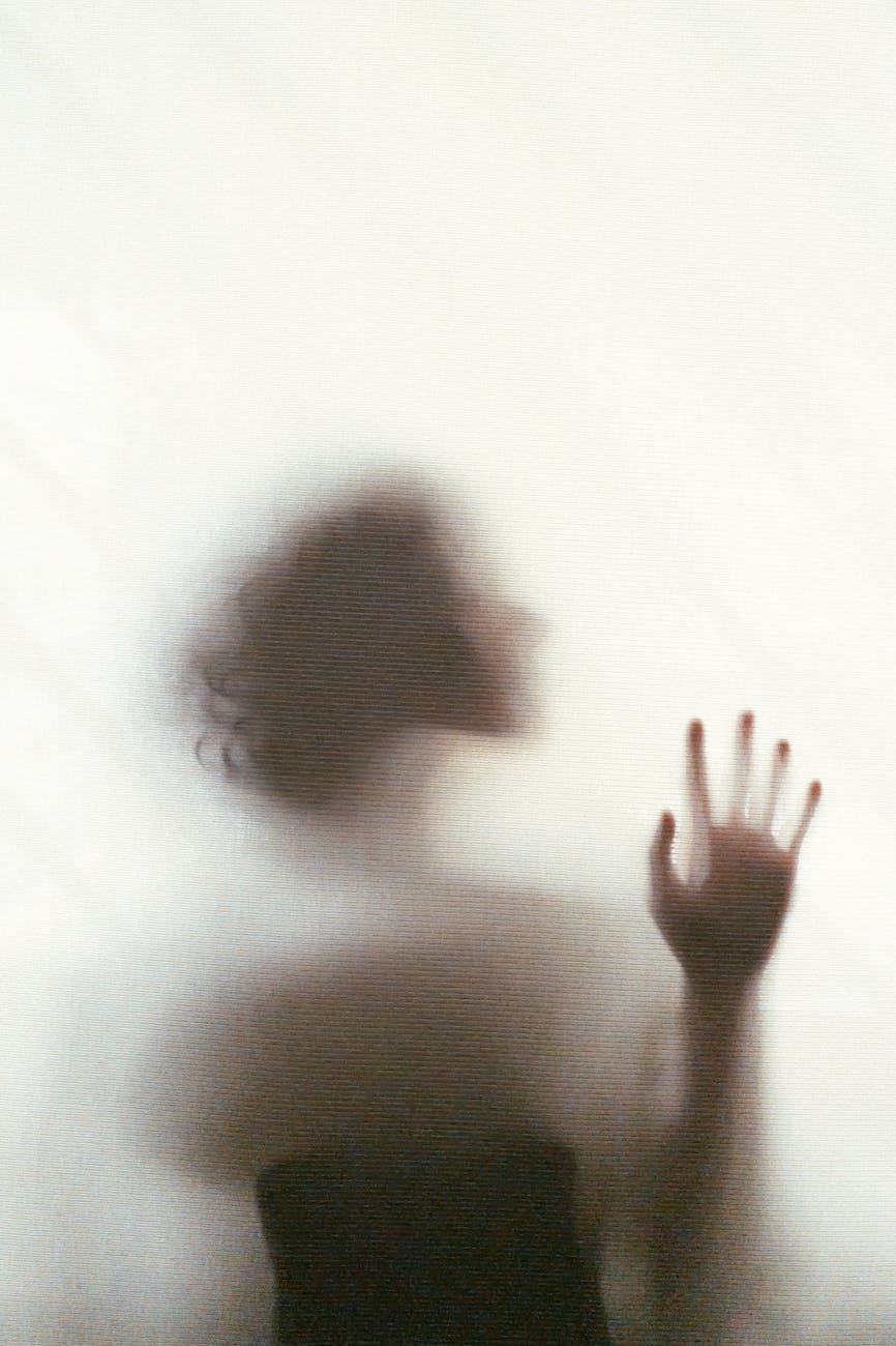 unrecognizable woman standing behind glass window