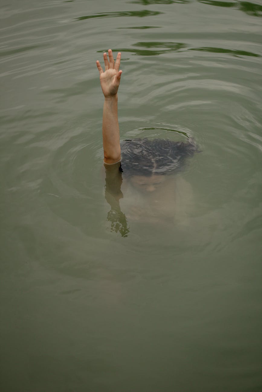 a person raising hand while under water