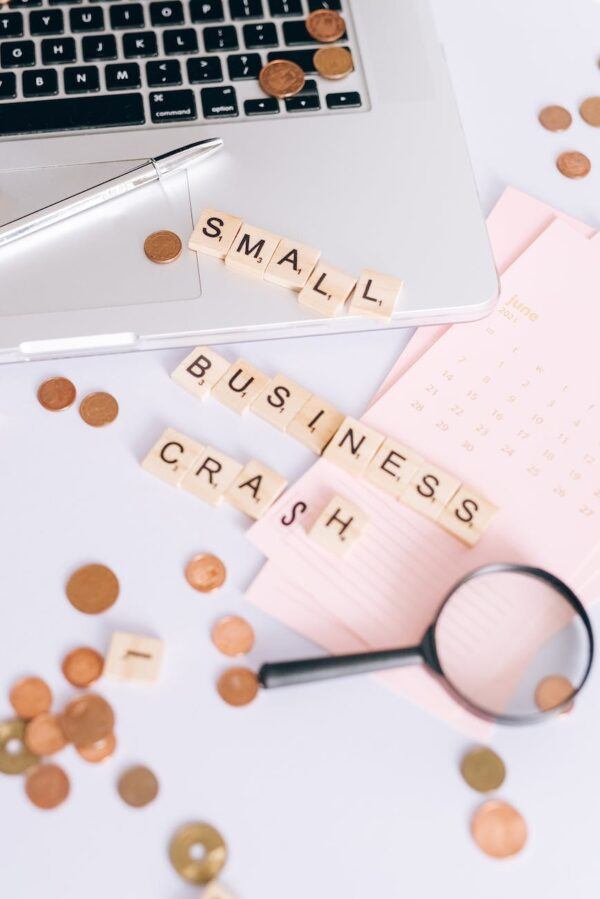 small business crash scrabble tiles on laptop and table top with coins