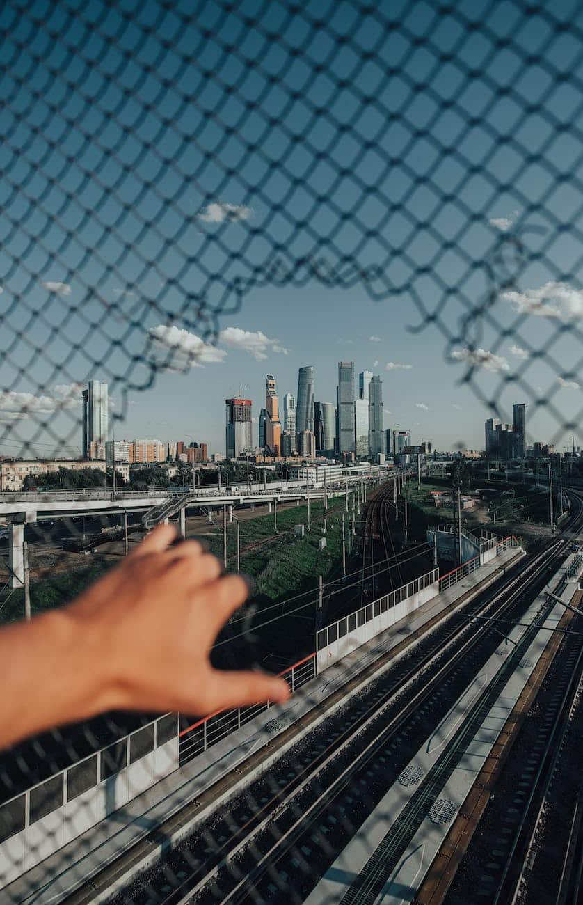 person holding on black metal fence