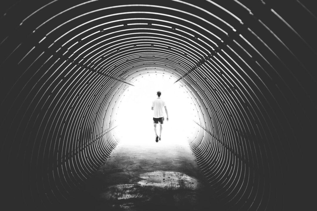 grayscale photo of man walking in hole