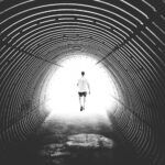 grayscale photo of man walking in hole