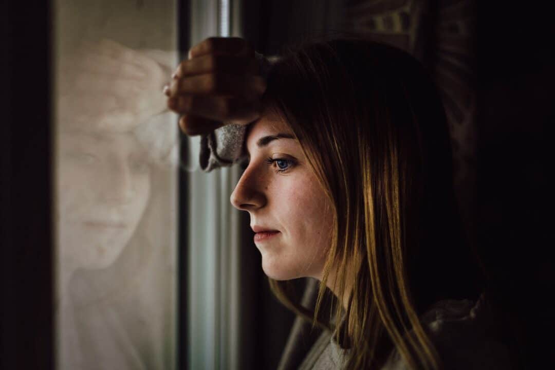 woman leaning on glass window