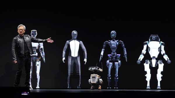 Jensen Huang sur scène présentant une gamme de robots humanoïdes et de petits robots